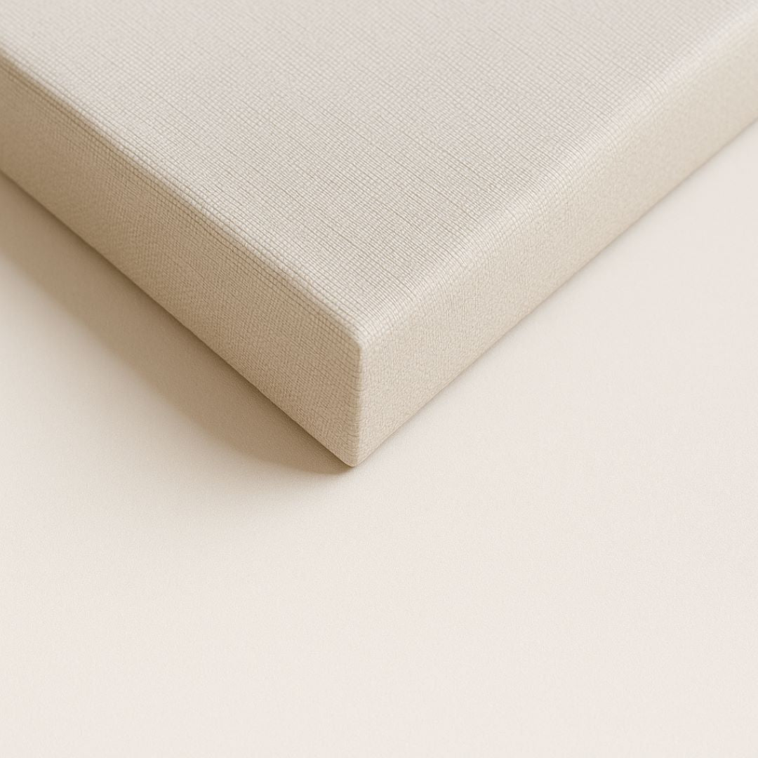 Detalhe aproximado do canto de uma tela canvas esticada no chassi com acabamento de borda infinita, destacando a textura do tecido nas laterais.